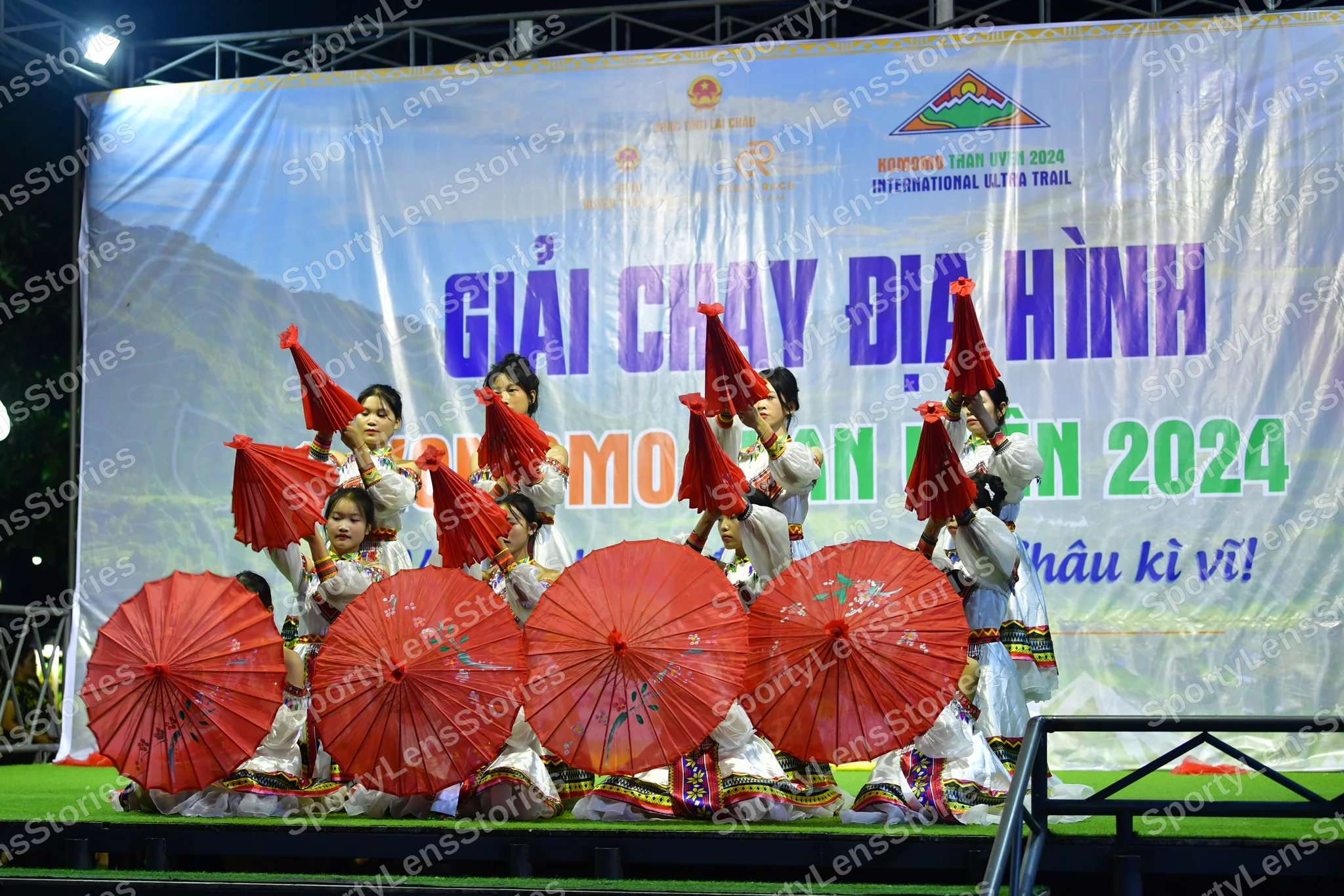 Marathon runner: The visible people are performers in white/cream-colored costumes with colorful 