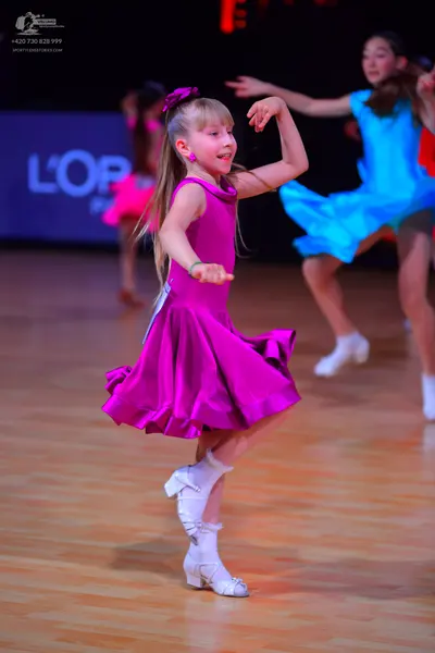 Dancesport competitor: Female dancer: magenta sleeveless latin dress with a flared skirt, made of satin