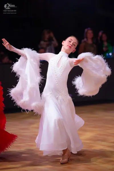 Dancesport competitor: Female dancer: white ballroom gown with a high-neck embellished bodice, large vo
