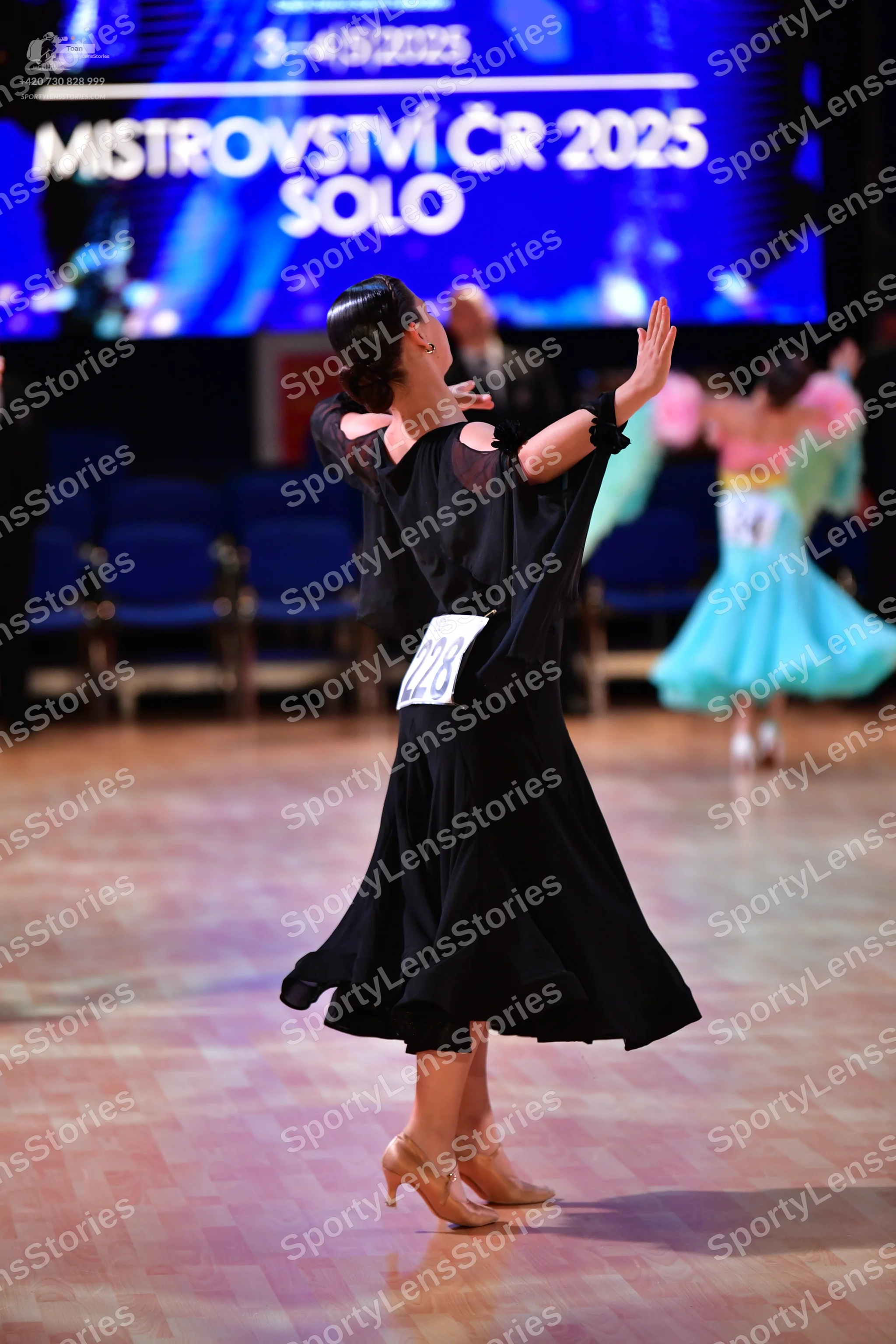 Dancesport competitor #228, #145: Female dancer (foreground): black ballgown with cutouts on the bodice