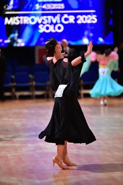 Dancesport competitor #228, #145: Female dancer (foreground): black ballgown with cutouts on the bodice