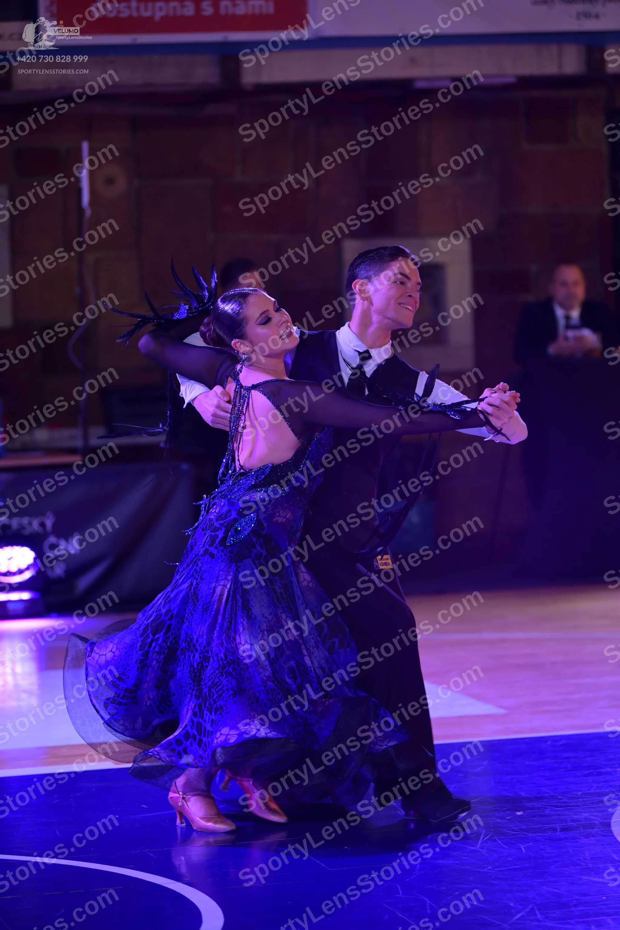 Dancesport competitor: Female dancer: dark blue and purple voluminous ballgown with patterned lace-like
