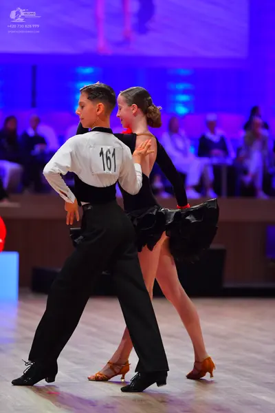 Dancesport competitor: Male dancer: white long-sleeved shirt and black trousers