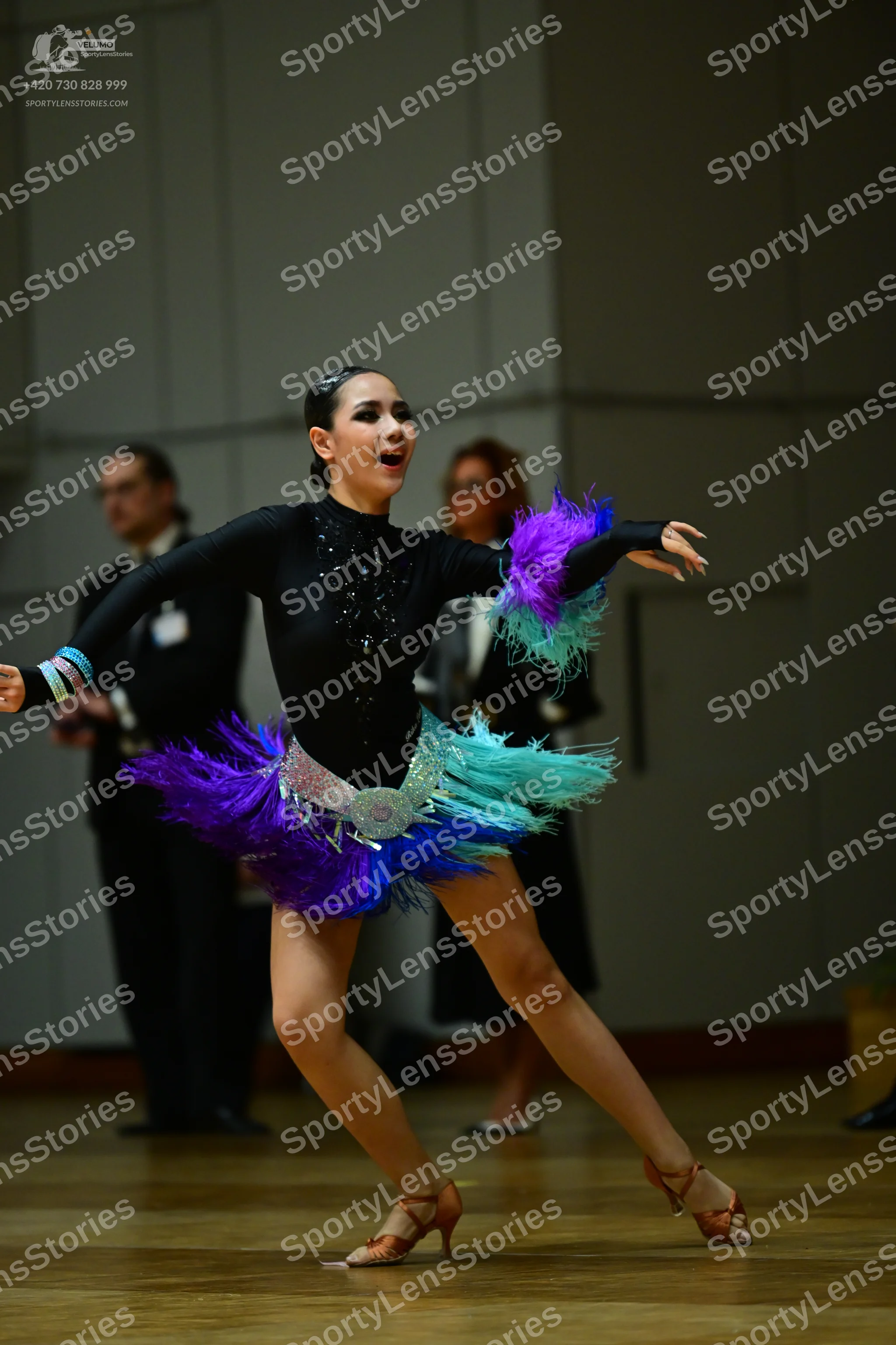 Dancesport competitor: Female dancer: black long-sleeved Latin bodysuit with a multi-colored (purple, b