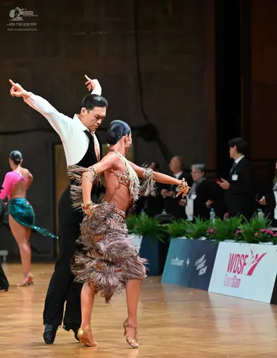 Dancesport competitor: Male dancer: white long-sleeved shirt, light pink necktie, and black trousers