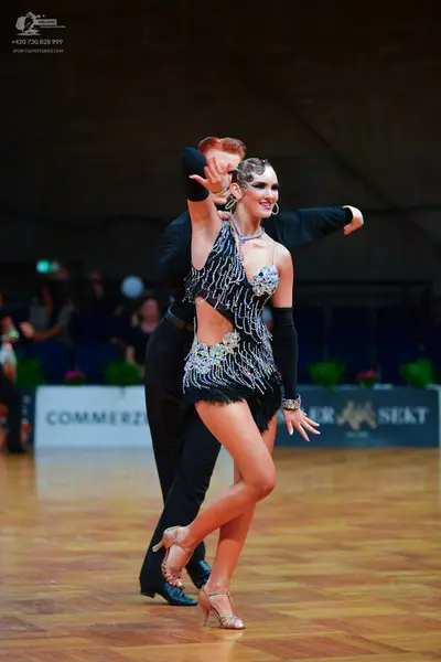 Dancesport competitor: Male dancer: black long-sleeved shirt and black trousers, with black gloves