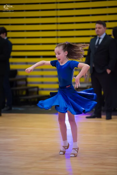 Dancesport competitor: ** Blue latin dress with a voluminous, sweeping skirt