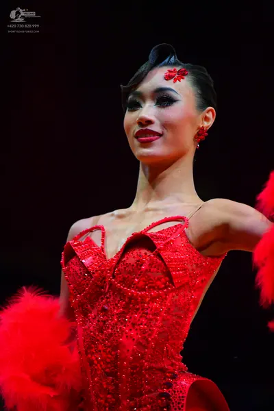Dancesport competitor: Female dancer: red latin dress with sequins and red feather accents