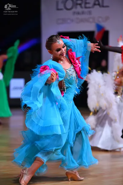 Dancesport competitor: Female dancer: cyan blue Latin dance dress with a sequined bodice, large pink fa
