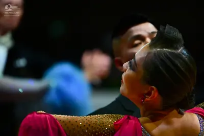 Dancesport competitor: Female dancer: bright pink Latin dress embellished with sparkling rhinestones