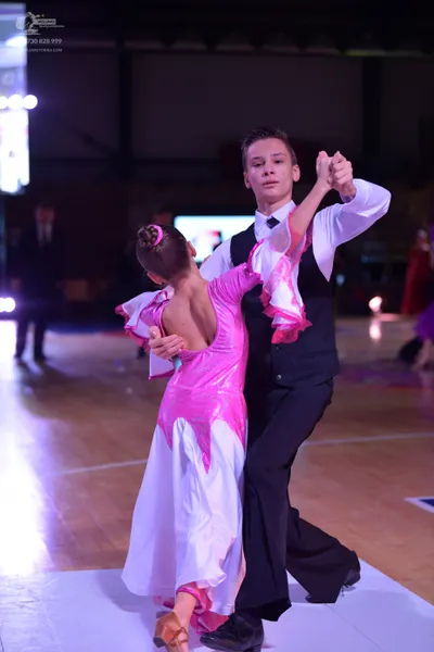 Dancesport competitor: Male dancer: white long-sleeved shirt, black waistcoat, and black trousers