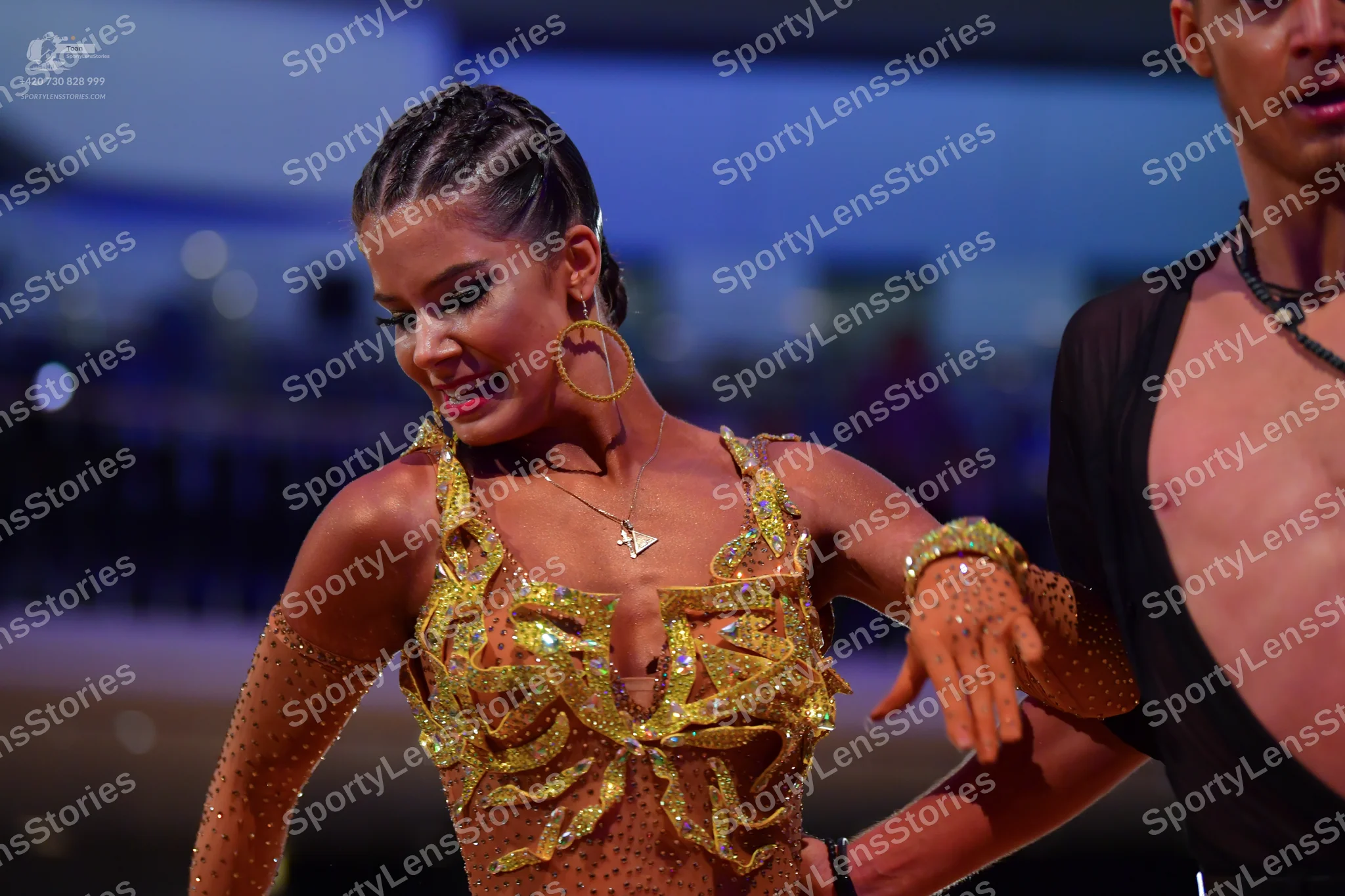 Dancesport competitor: Female dancer: gold/bronze sequined Latin dress with a plunging neckline and lon