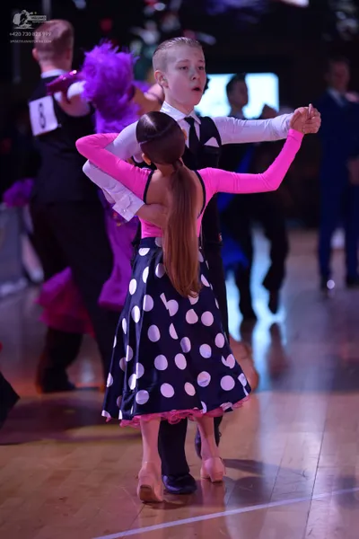 Dancesport competitor: Male dancer: black waistcoat over a white long-sleeved shirt with a black tie an