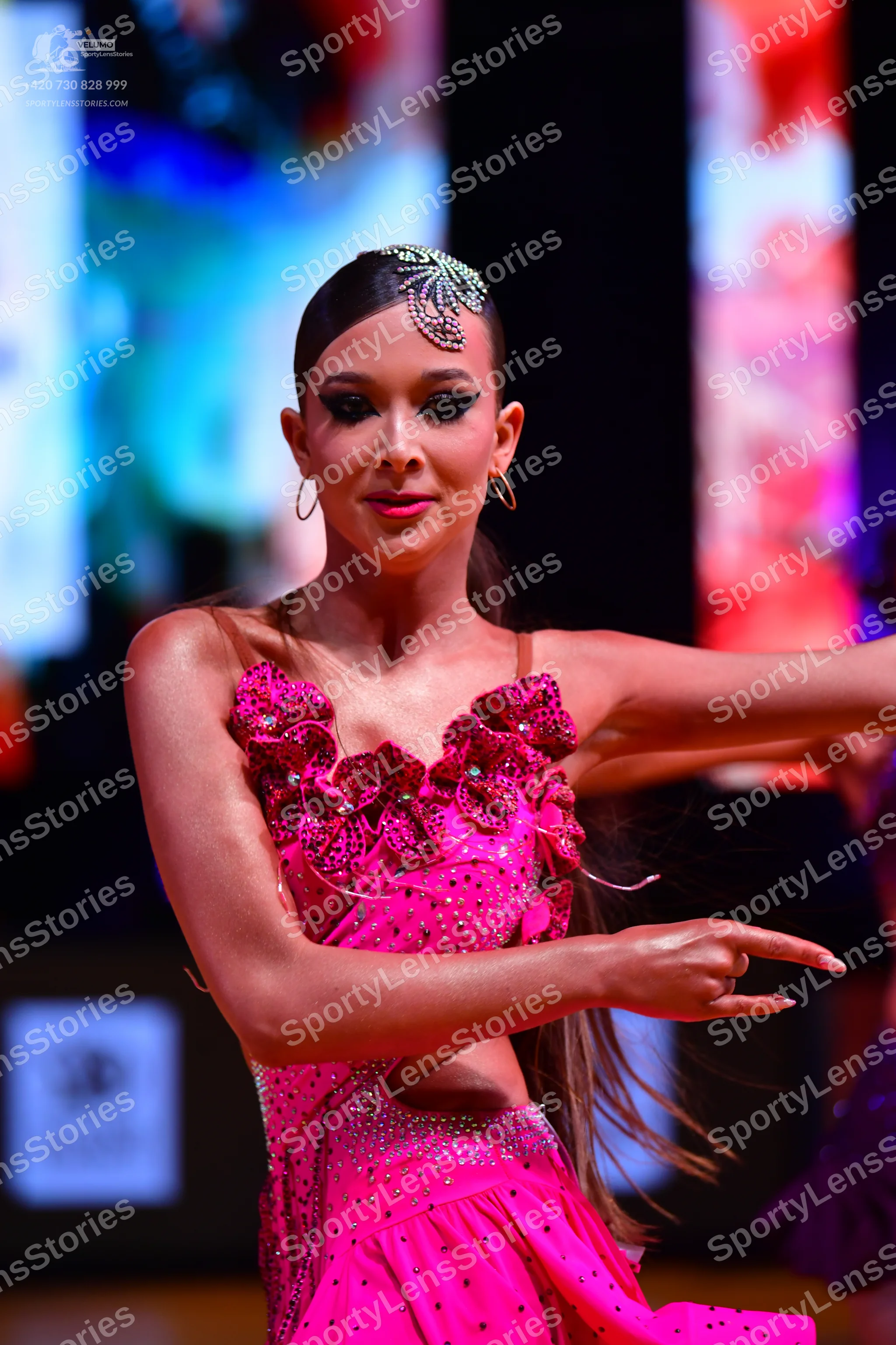 Dancesport competitor: Female dancer: bright pink/magenta Latin dress with sequins, floral-like 3D fabr