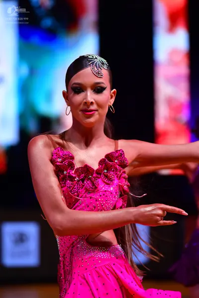 Dancesport competitor: Female dancer: bright pink/magenta Latin dress with sequins, floral-like 3D fabr