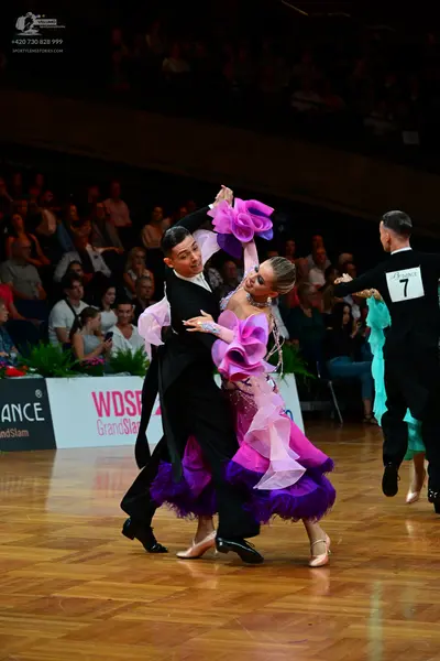 Dancesport competitor: Male dancer (left): black long-sleeve shirt and black trousers