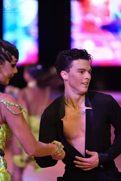 Dancesport competitor: Male dancer: black open-chested shirt with a silver chain necklace