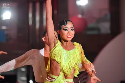 Dancesport competitor: Female dancer: lime green latin dress with long fringe and sequins