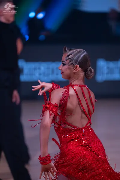 Dancesport competitor: Female dancer: red Latin dress with sequins and long fringe