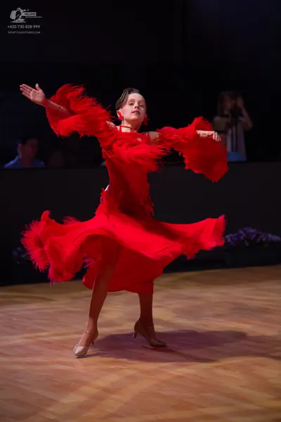 Dancesport competitor: Female dancer: red latin dress with long fringe and red earrings