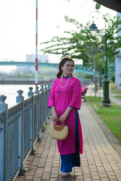 Dancesport competitor: Female dancer: pink long-sleeved tunic with navy blue trim, navy blue pants, pea