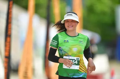 Marathon runner #554: Runner 1: green jersey with yellow pattern, black long-sleeve shirt, white cap