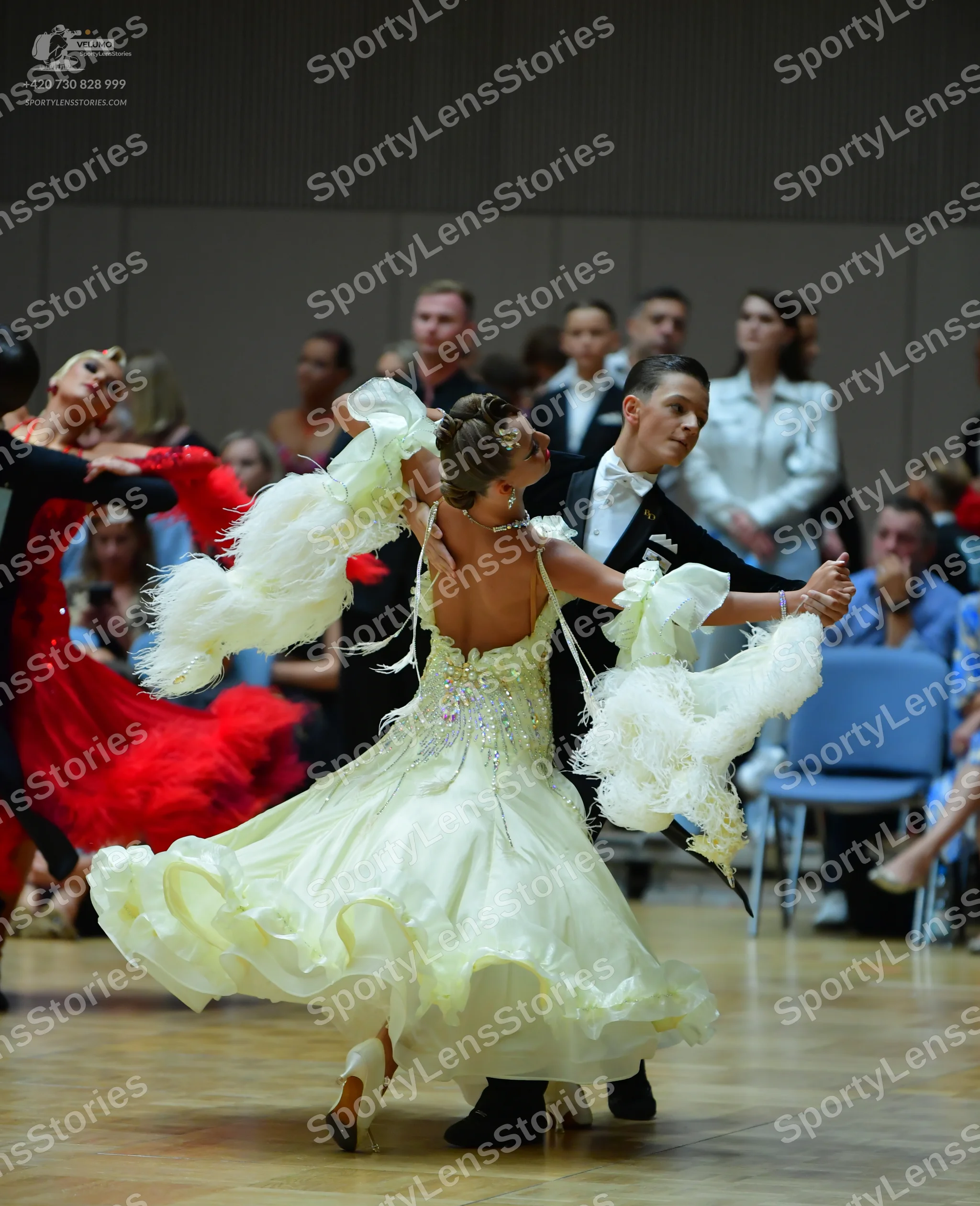 Dancesport competitor: Main female dancer: pale yellow ballgown with large, fluffy white ruffles on the