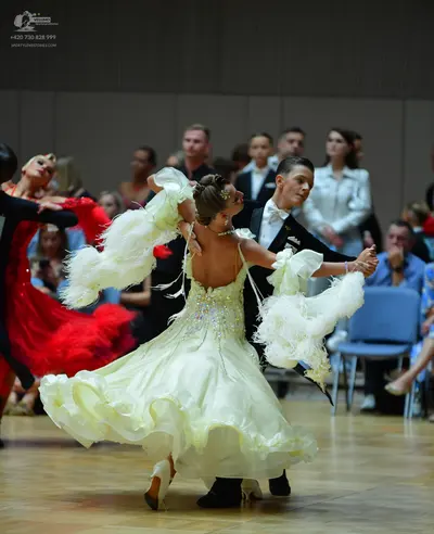 Dancesport competitor: Main female dancer: pale yellow ballgown with large, fluffy white ruffles on the