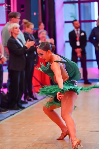 Dancesport competitor: Female dancer: green Latin dress with fringe