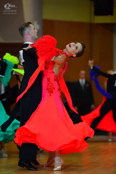 Dancesport competitor: Male dancer in foreground: black suit, white shirt, and black bow tie