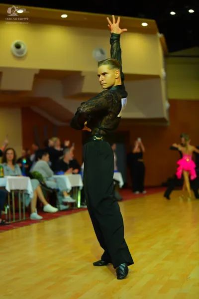 Dancesport competitor: Male dancer: black, long-sleeved, patterned mesh top and black trousers