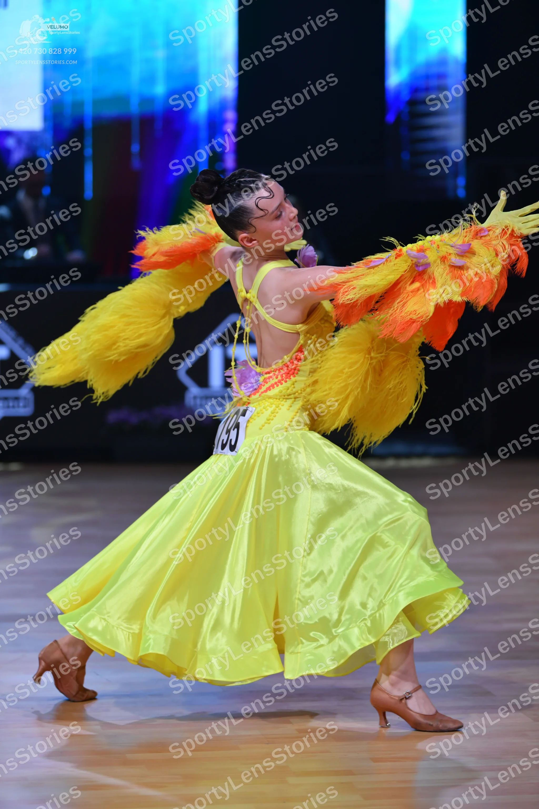 Dancesport competitor: Female dancer: bright yellow ballroom dress with large, voluminous yellow and or