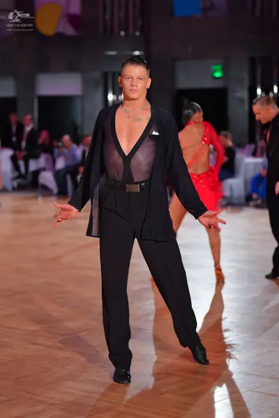 Dancesport competitor: Male dancer: black ensemble consisting of a sheer black jacket and black trouser