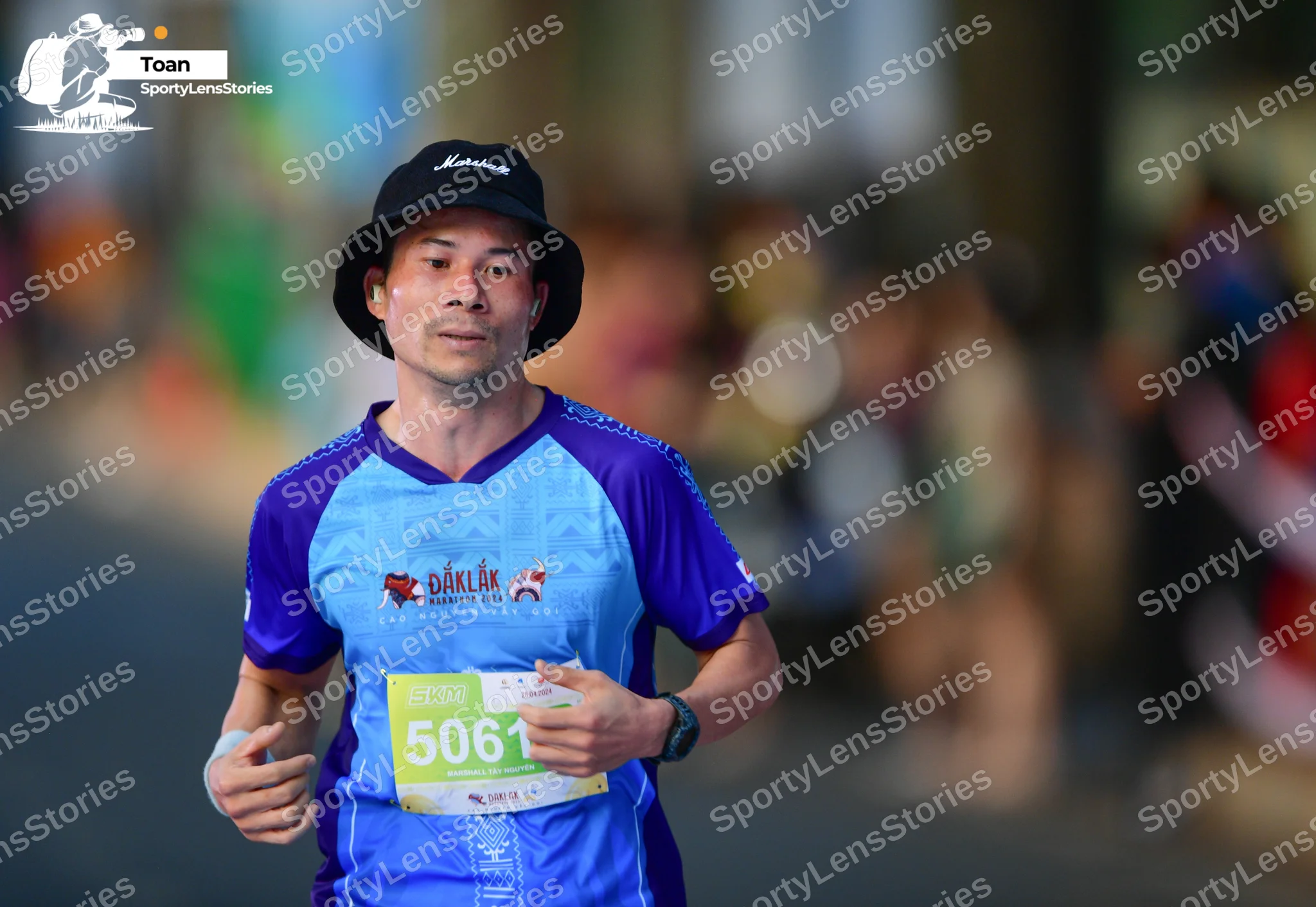 Marathon runner #5061: Runner 1: blue and purple short-sleeved shirt, black bucket hat, black watch, wh