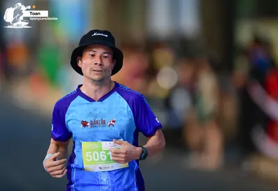 Marathon runner #5061: Runner 1: blue and purple short-sleeved shirt, black bucket hat, black watch, wh