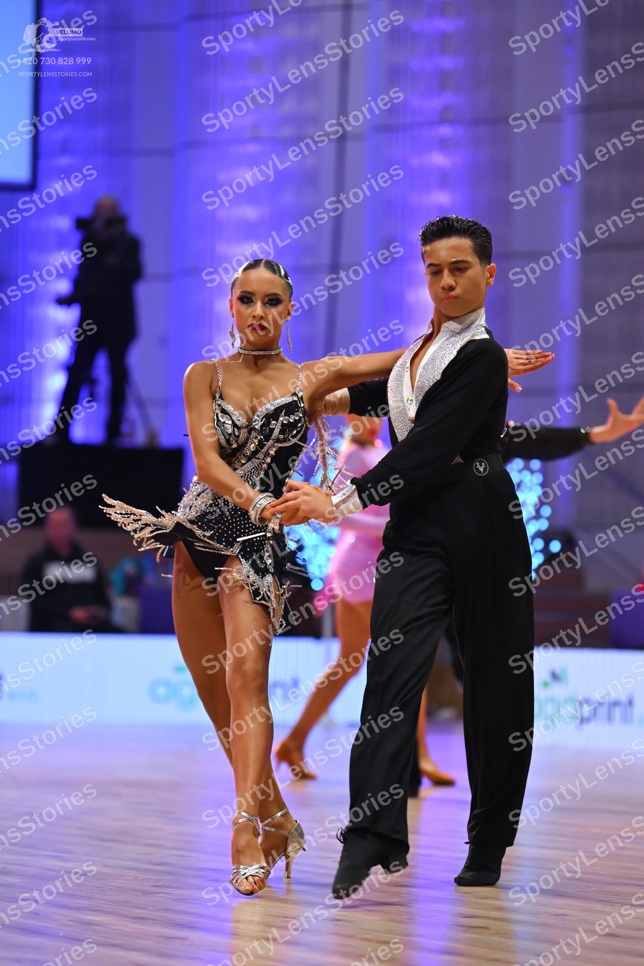Dancesport competitor: Female dancer: black latin dress decorated with silver sequins and rhinestones,