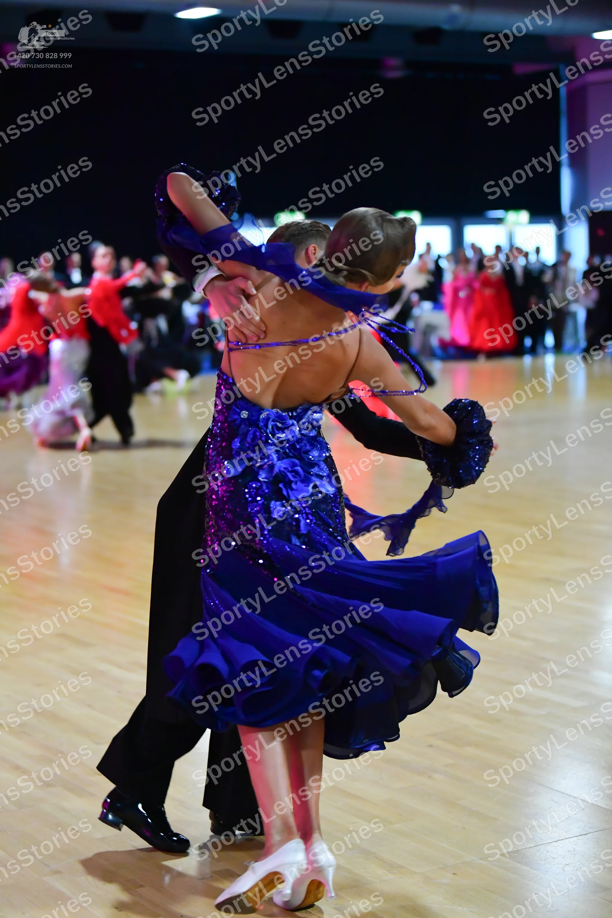 Dancesport competitor: Female dancer: royal blue ballroom dress with a sequined and lace bodice, thin s