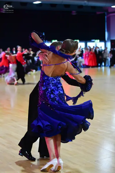 Dancesport competitor: Female dancer: royal blue ballroom dress with a sequined and lace bodice, thin s