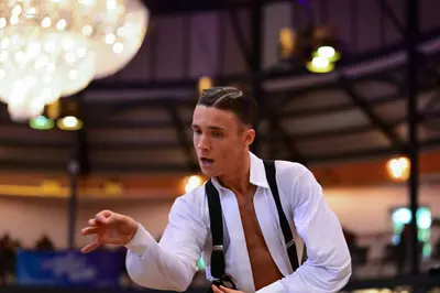 Dancesport competitor: Male dancer: white long-sleeved shirt, unbuttoned, with black suspenders