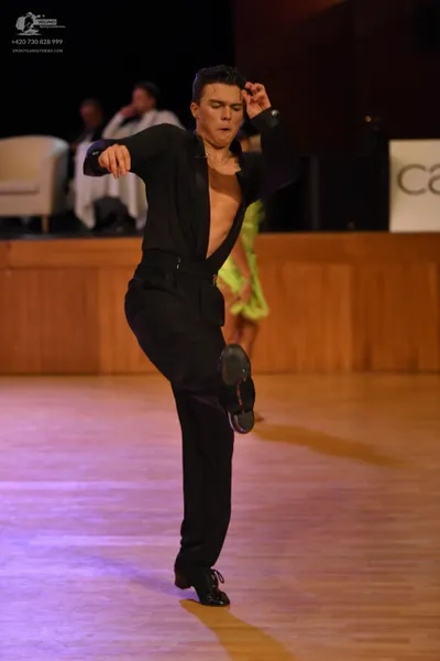 Dancesport competitor: Male dancer: black long-sleeved top, open at the chest, and black trousers