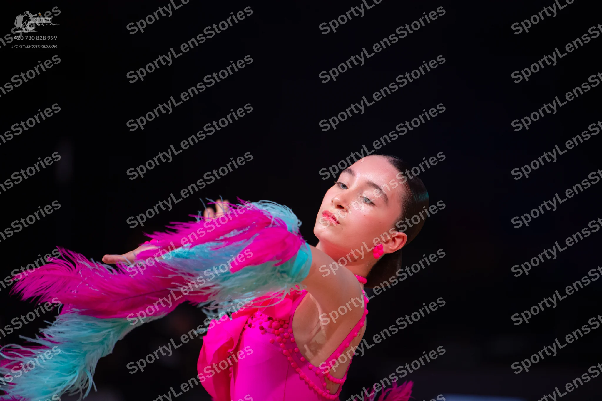 Dancesport competitor: Female dancer: bright pink/magenta Latin dress with long, flowing pink and light