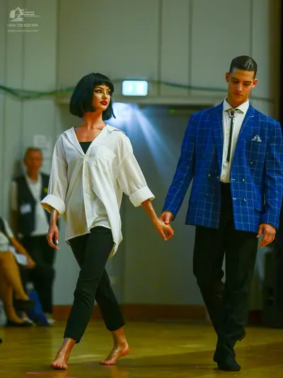 Dancesport competitor: Female dancer: white oversized button-down shirt and black trousers