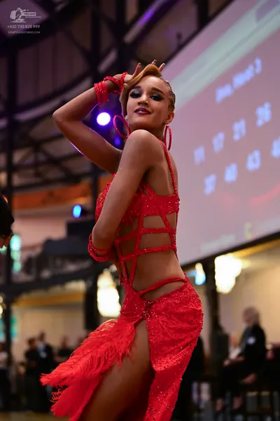 Dancesport competitor: Female dancer: red latin dress with sequins and fringe, featuring multiple strap