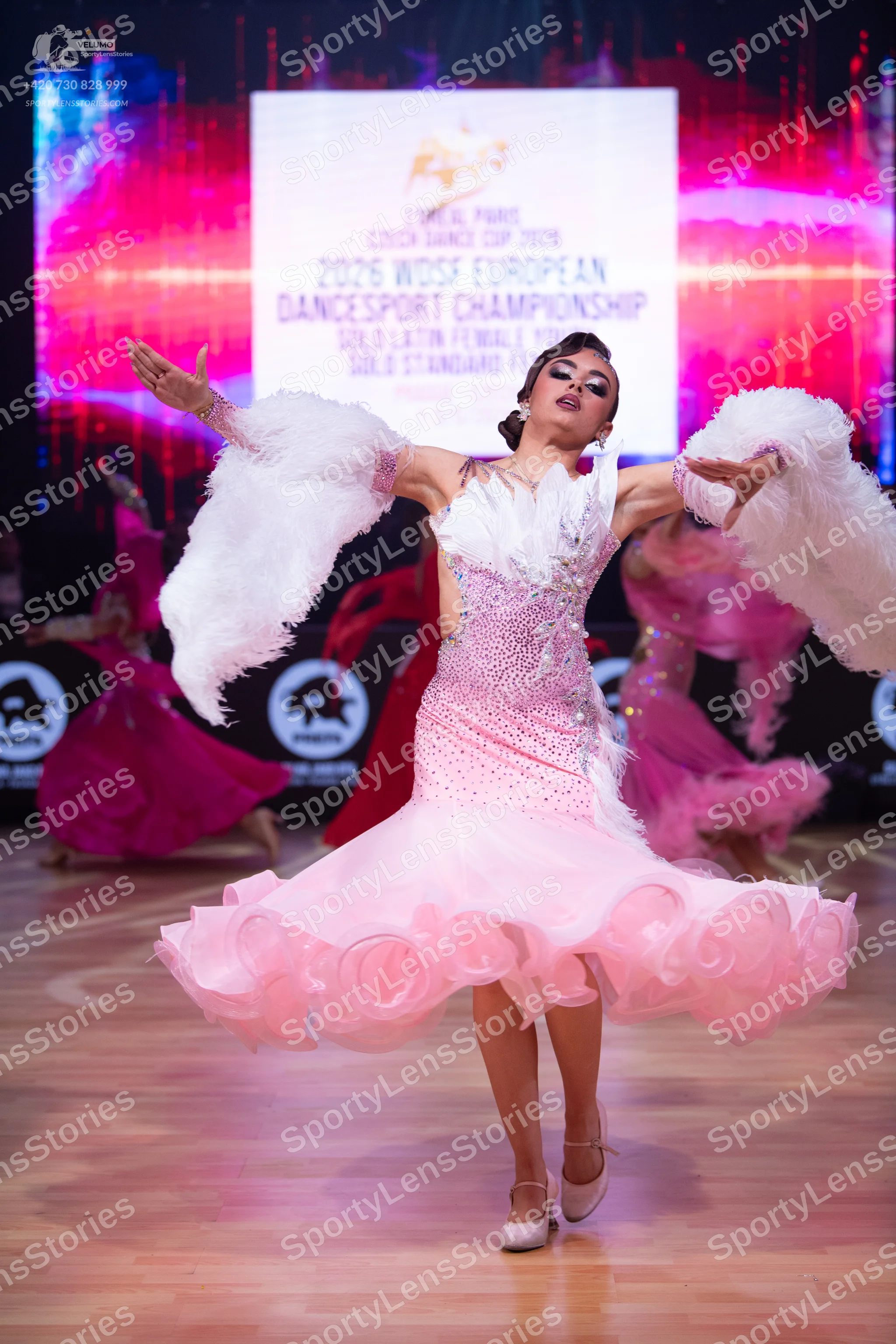 Dancesport competitor: Female dancer: pale pink ballroom dress with a heavily sequined bodice, volumino