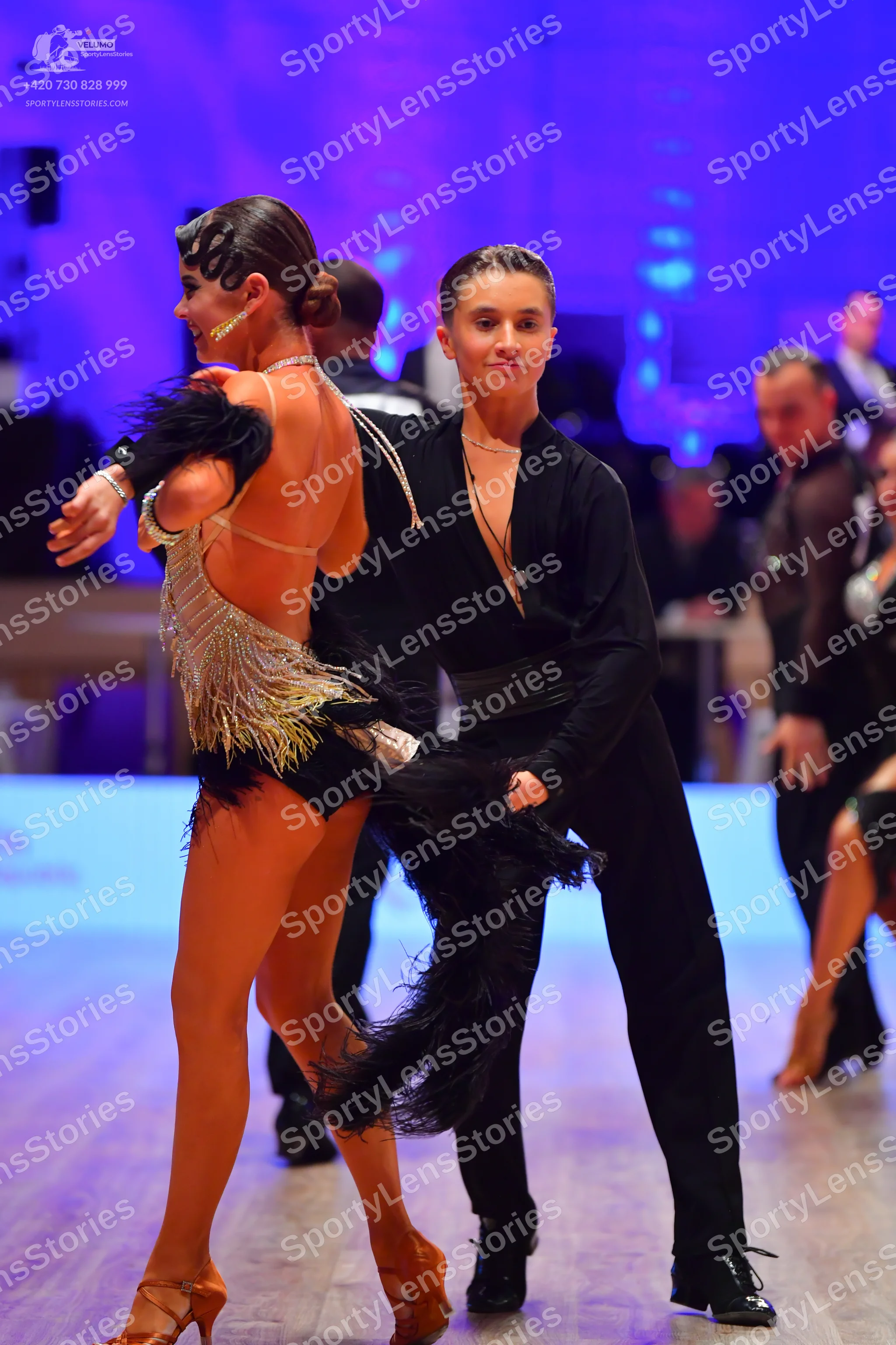 Dancesport competitor: Female dancer: silver sequined Latin dance top with a black skirt adorned with l
