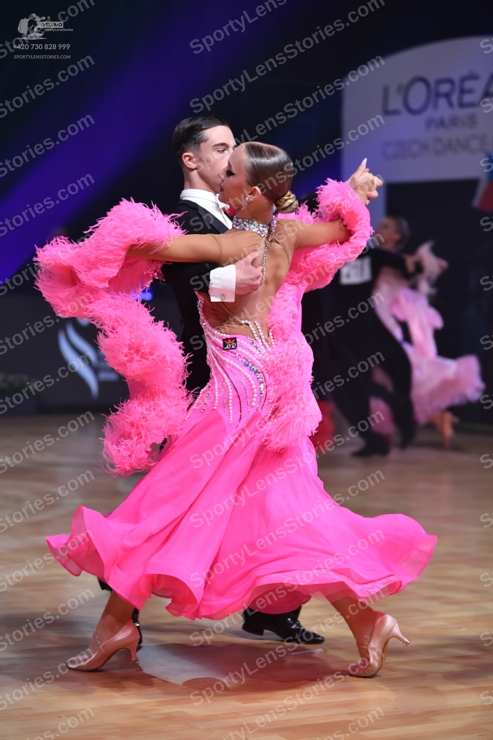 Dancesport competitor: Female dancer: pink ballroom dress with a voluminous skirt, large pink feather t