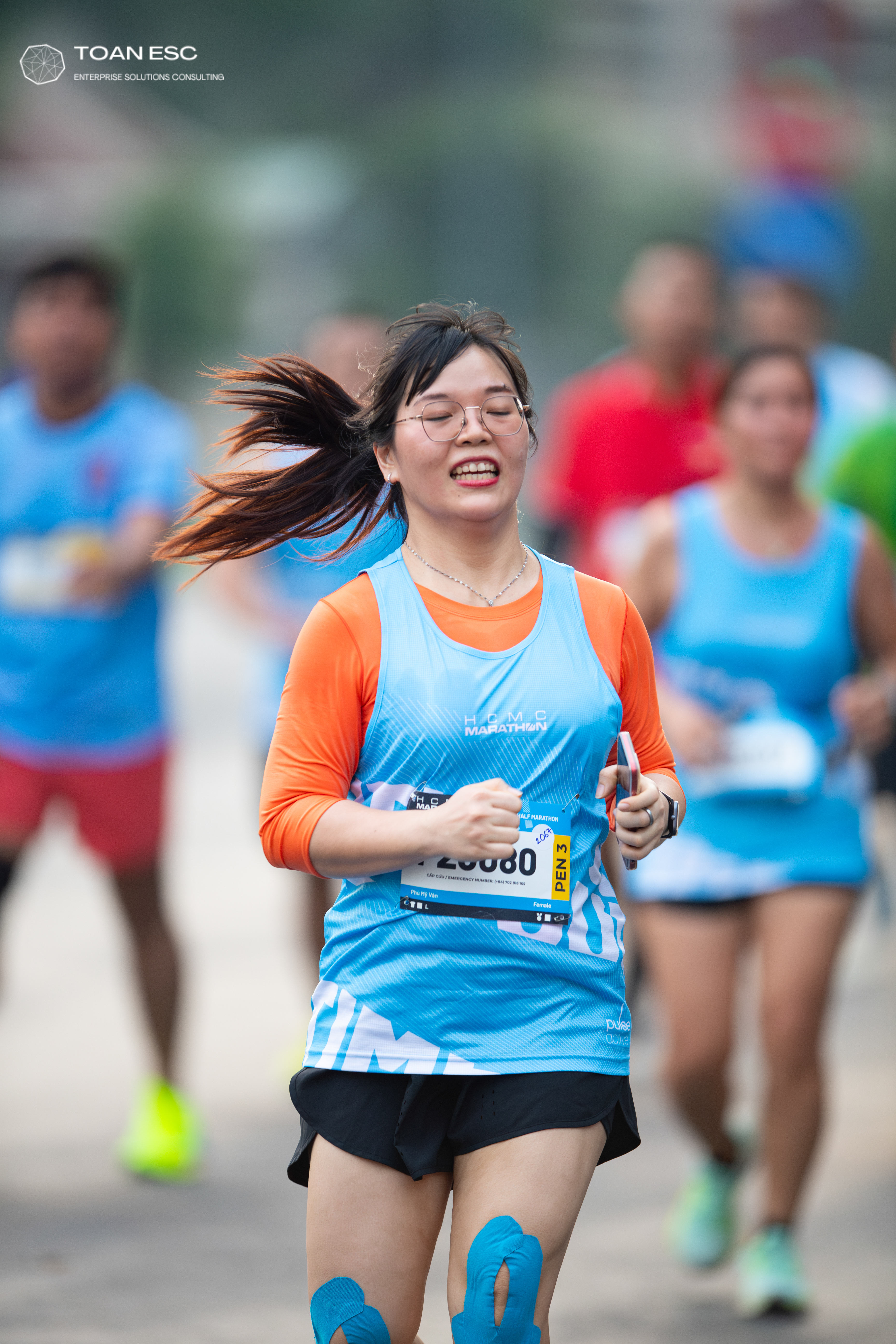 Marathon runner #20880: Runner 1: light blue tank top, orange long-sleeved shirt, black shorts, blue kin