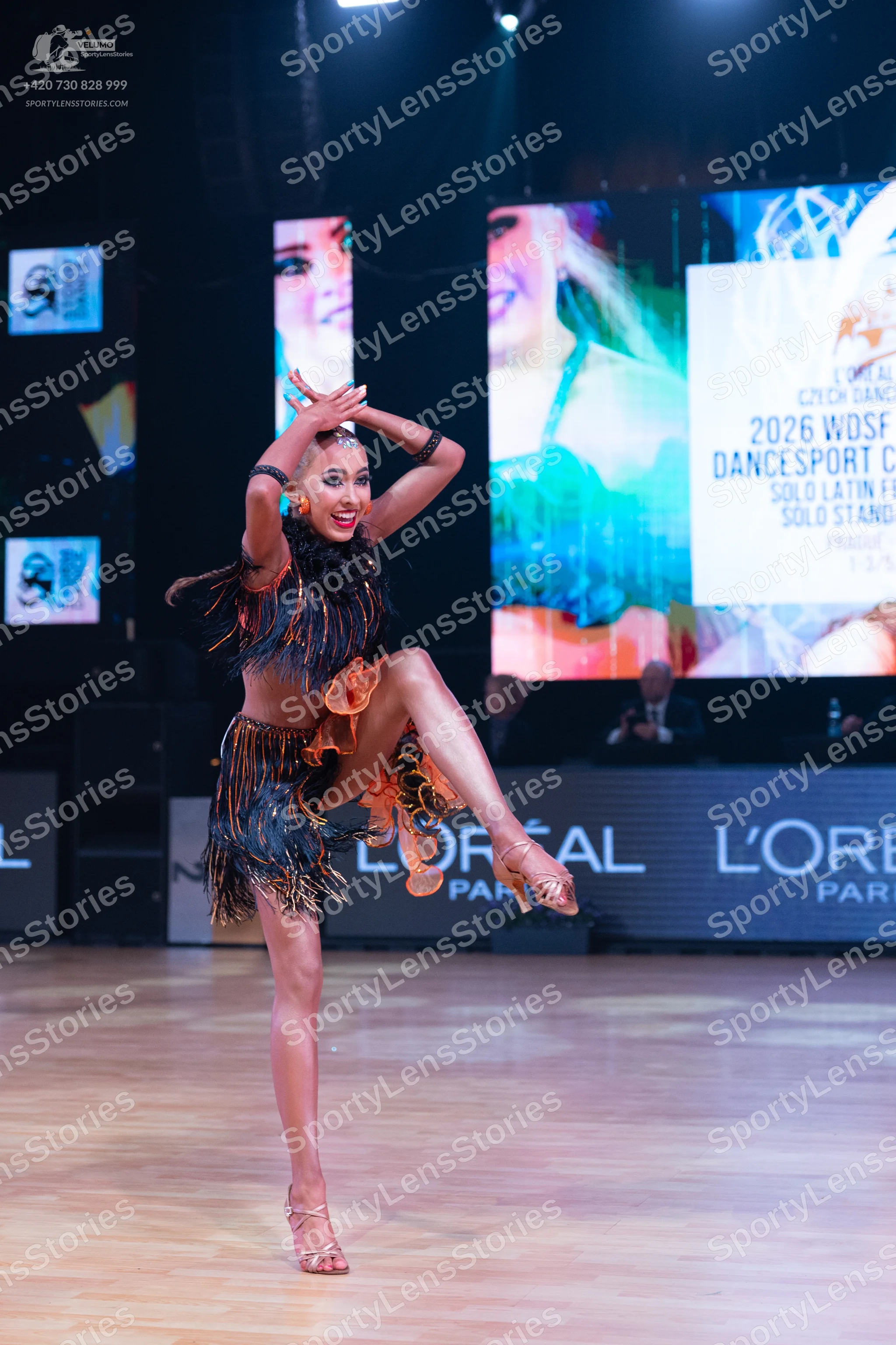 Dancesport competitor: Female dancer: black and bronze two-piece latin dance costume with long, heavy f