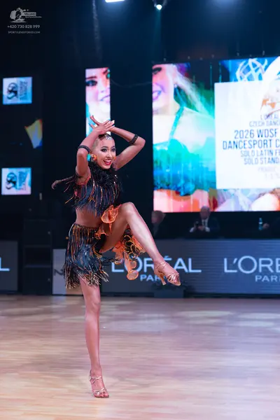 Dancesport competitor: Female dancer: black and bronze two-piece latin dance costume with long, heavy f