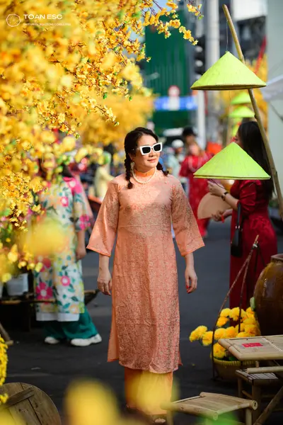 Dancesport competitor: Female dancer (center): peach-colored long tunic with a subtle pattern and match
